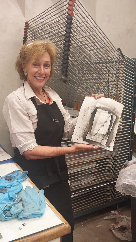 Ann Hargis holding a print created at the Doel Reed Center